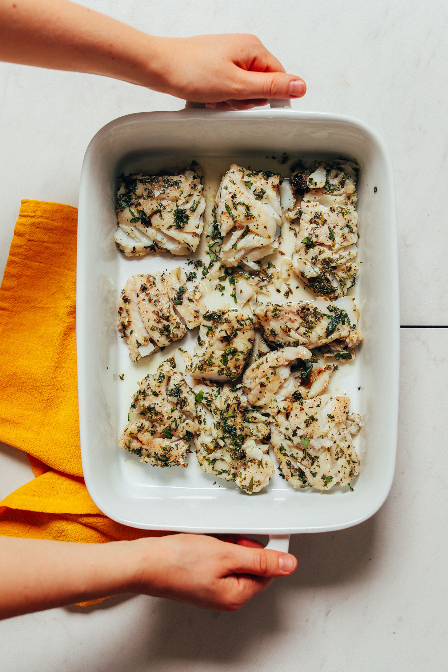 Baking pan of Baked White Fish seasoned with fresh herbs