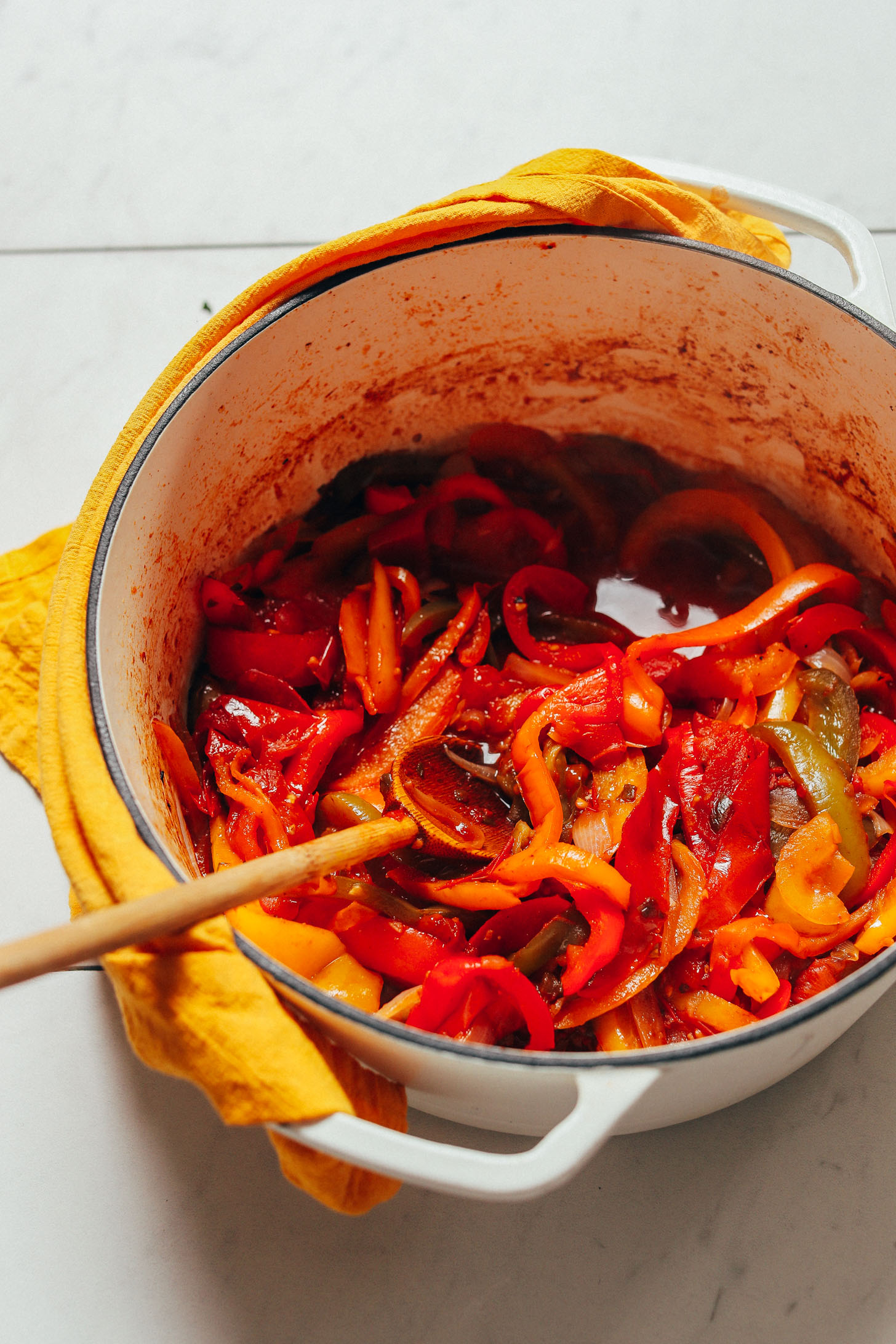 Dutch oven filled with freshly sautéed onions, bell peppers, and other ingredients for our Baked White Fish recipe
