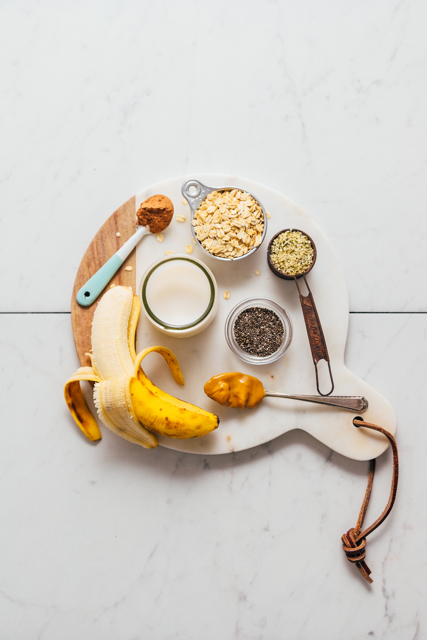 Marble and wood cutting board filled with ingredients for making our Protein Powder-Free Chocolate Protein Shake