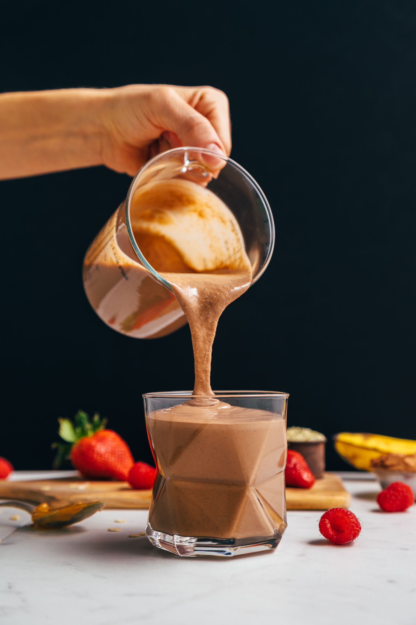 Pouring a serving of our Chocolate Protein Shake from a measuring glass