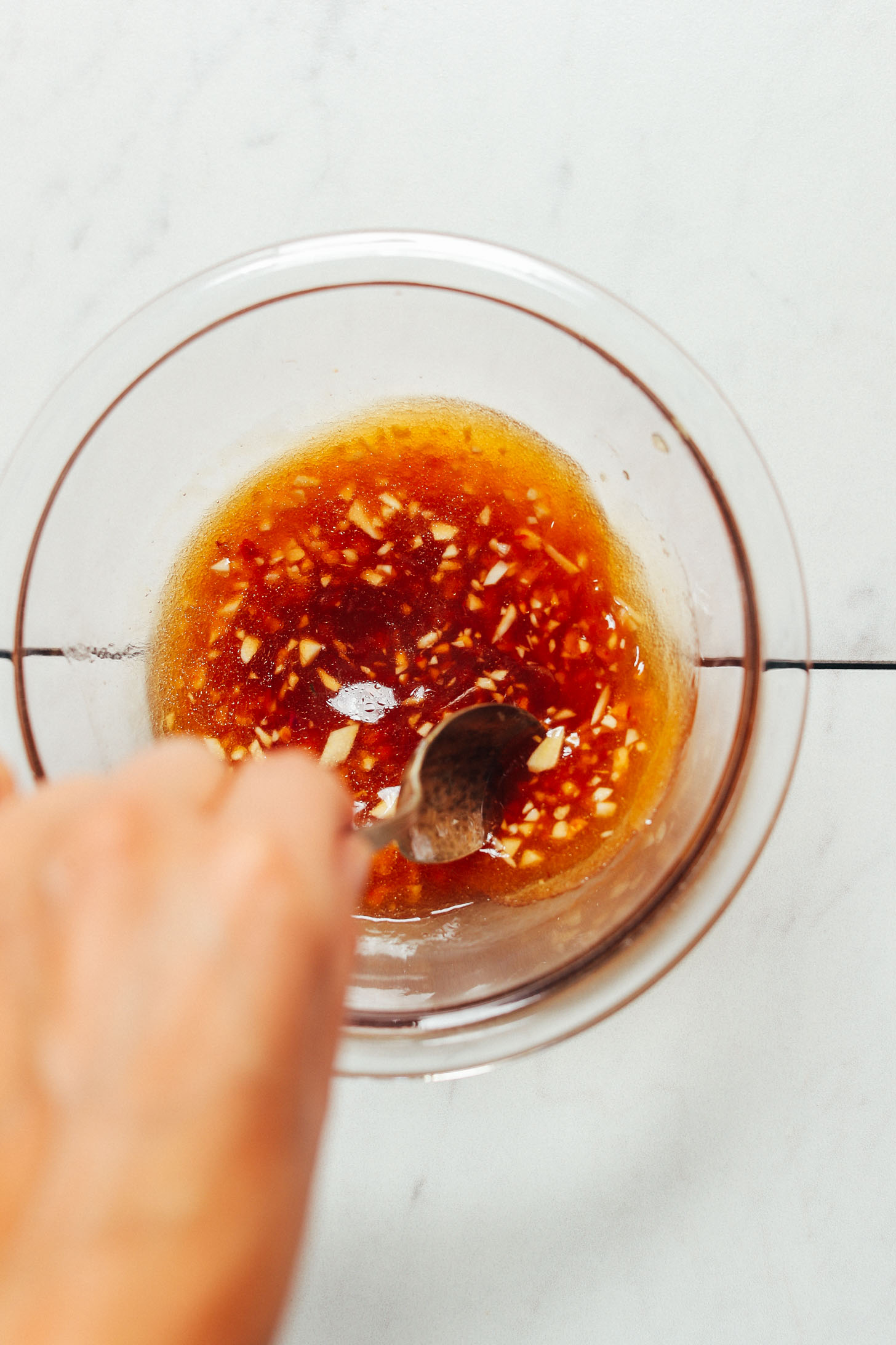 Stirring a bowl of Garlic Sesame Dressing for adding to Crispy Miso Chickpea Bowls