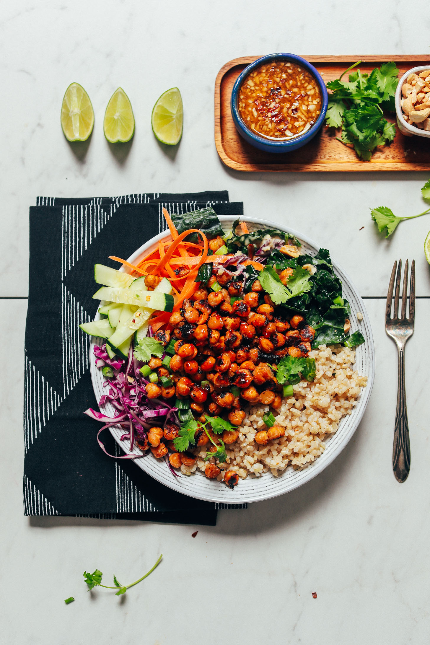 Crispy Miso Chickpea Bowl alongside fresh lime, chopped cashews, dressing, and cilantro for serving