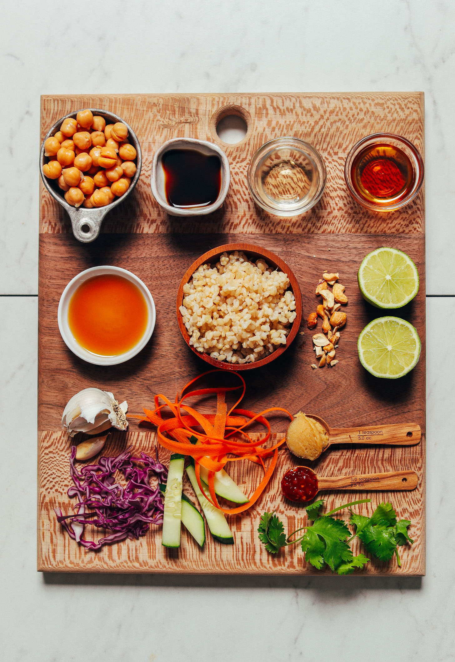 Wood cutting board with ingredients for making our Crispy Miso Chickpea Bowls with Garlic Sesame Dressing recipe