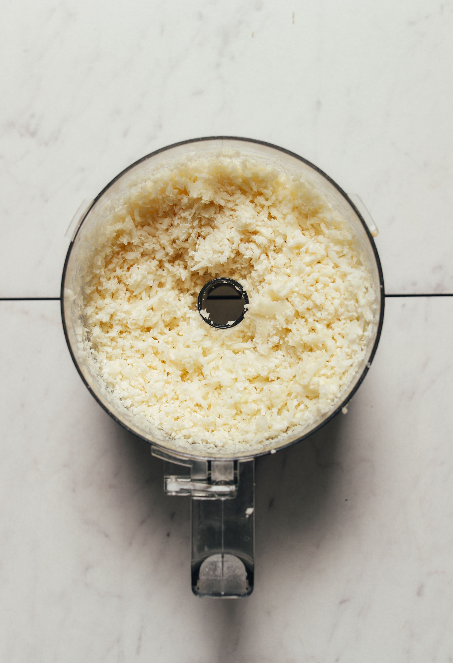 Food processor filled with freshly made homemade cauliflower rice