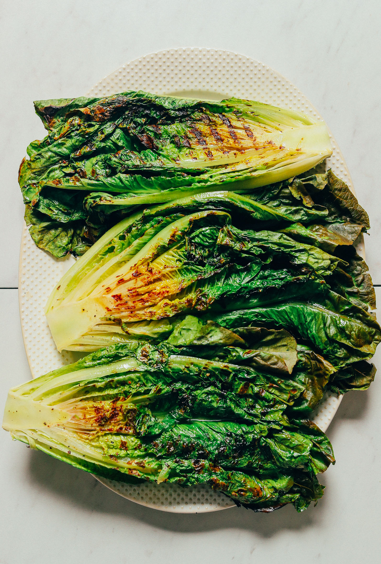 Platter of halved romaine heads grilled on a grill pan
