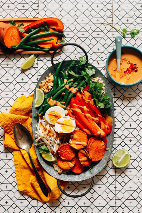 Tray of our delicious Gado Gado recipe beside a bowl of Spicy Peanut Sauce