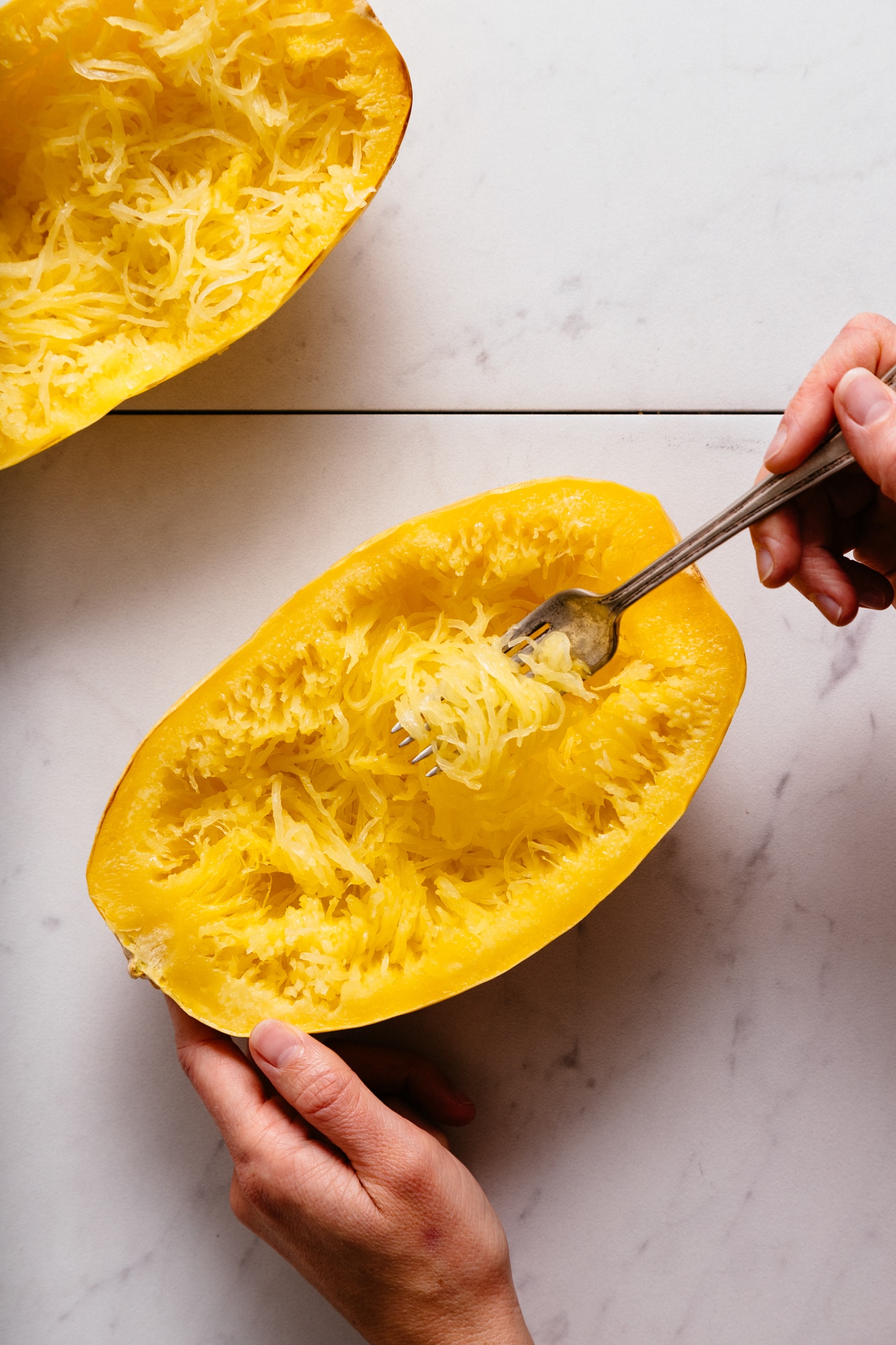 Using a fork to remove strands from a perfectly roasted spaghetti squash