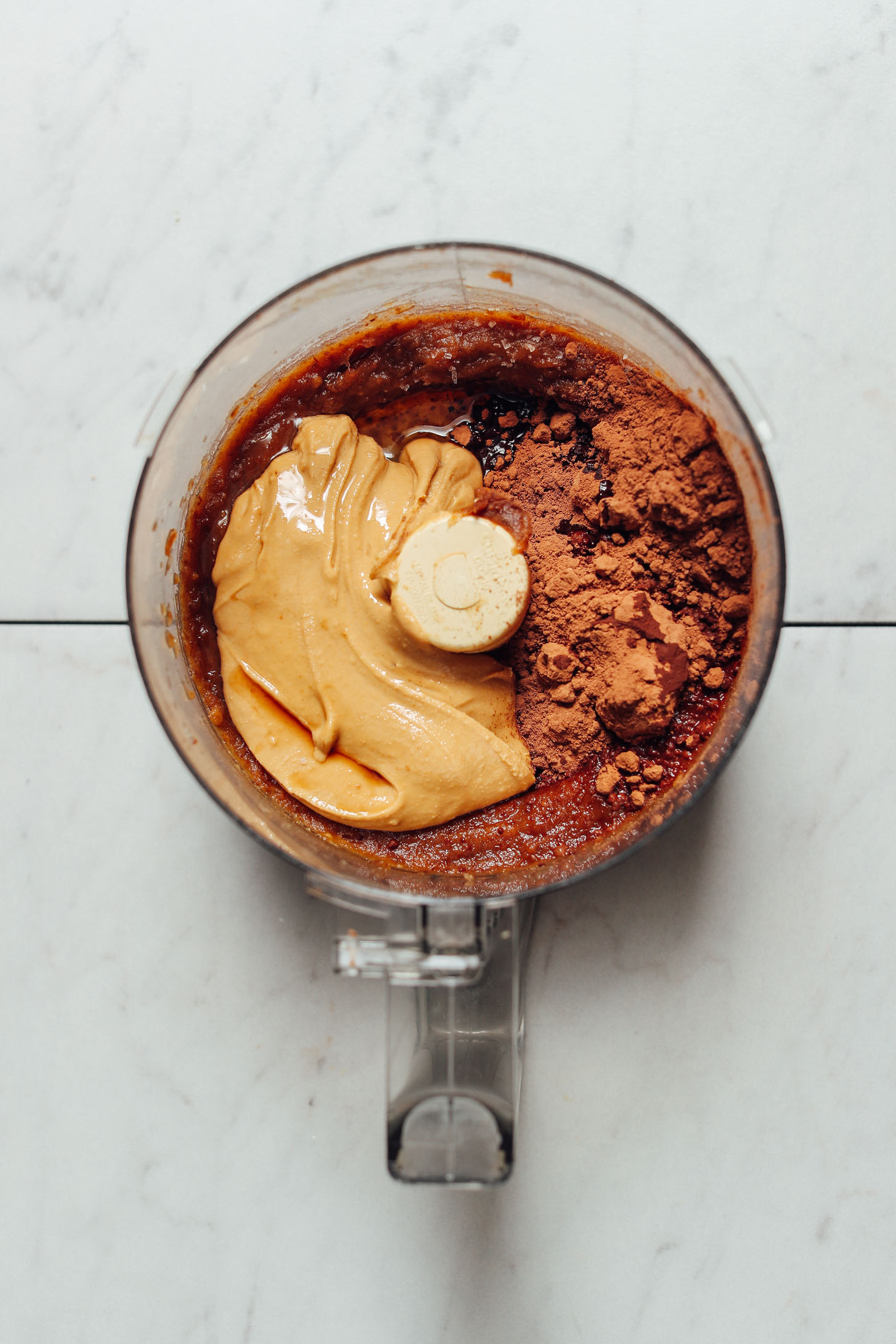 Food processor filled with ingredients for making our Vegan Chocolate Frosting recipe