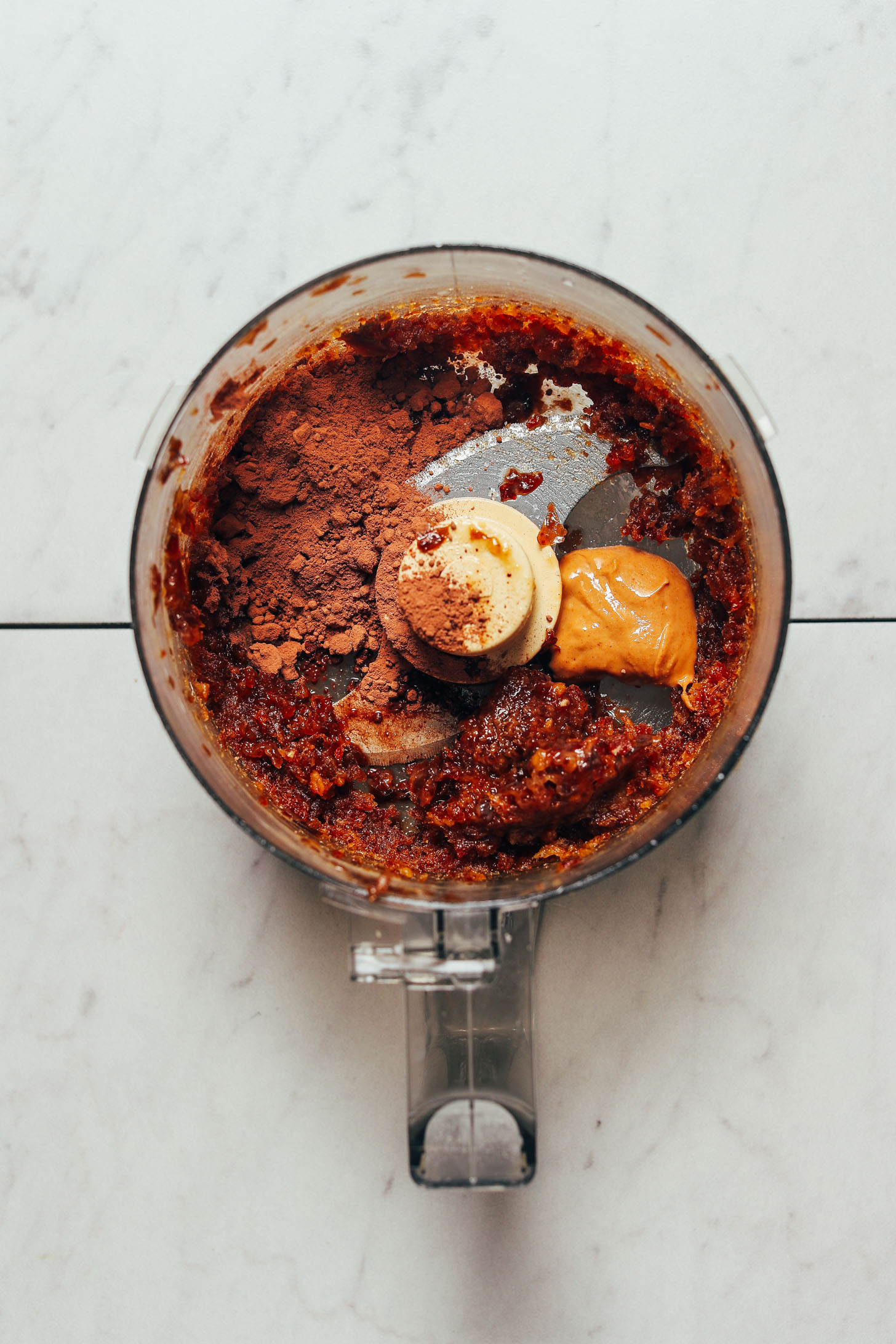 Food processor filled with ingredients for making our grain-free Vegan Chocolate Truffles