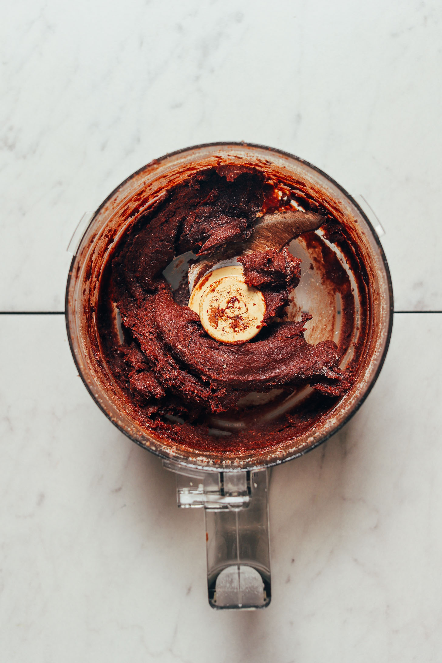 Food processor full of freshly processed fudgy mixture for making Vegan Chocolate Truffles