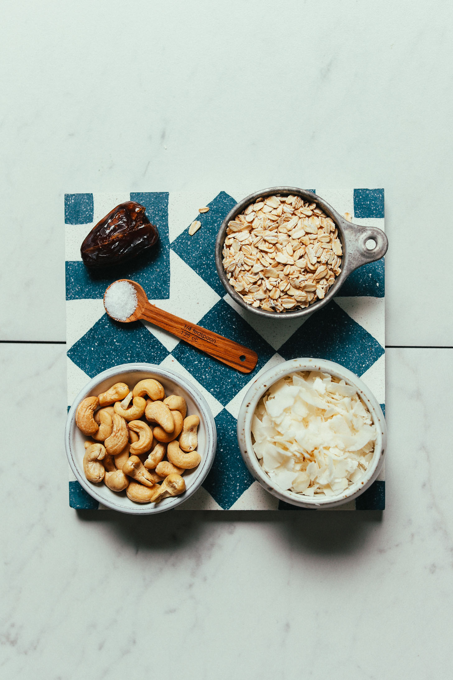 Blue and white tile with ingredients for making our homemade Cashew Oat Coconut Milk Creamer recipe