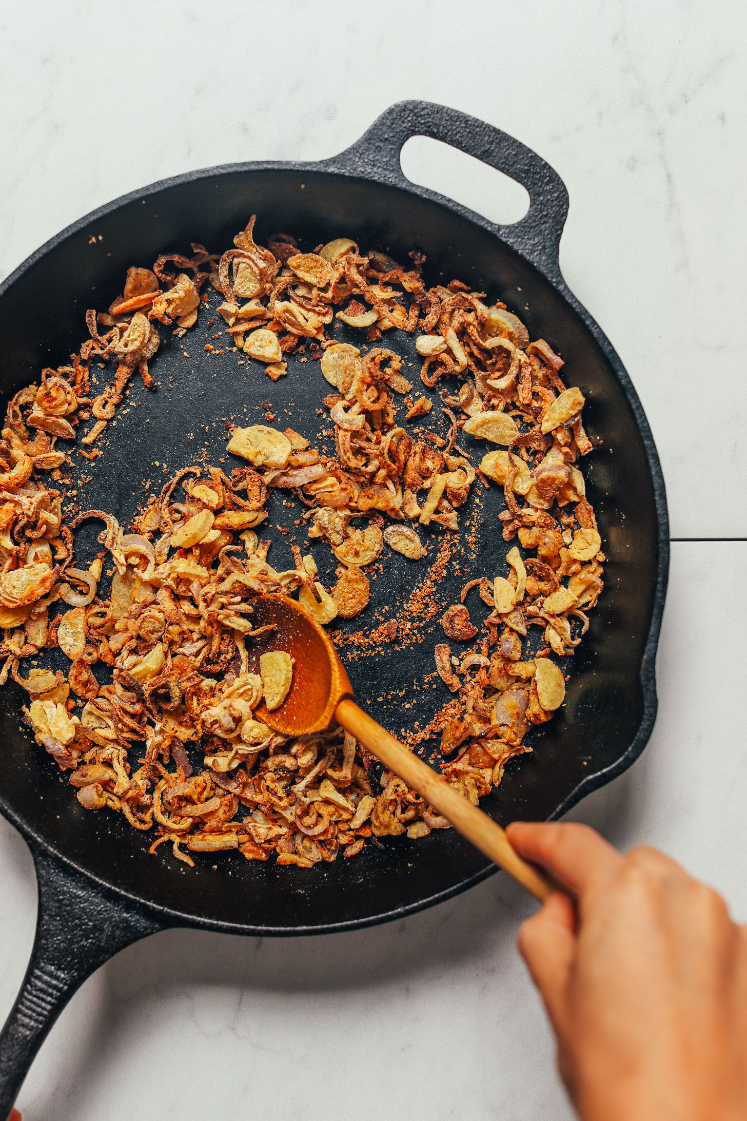 Cooking crispy shallots in a skillet to make our Grain-Free Mujadara recipe