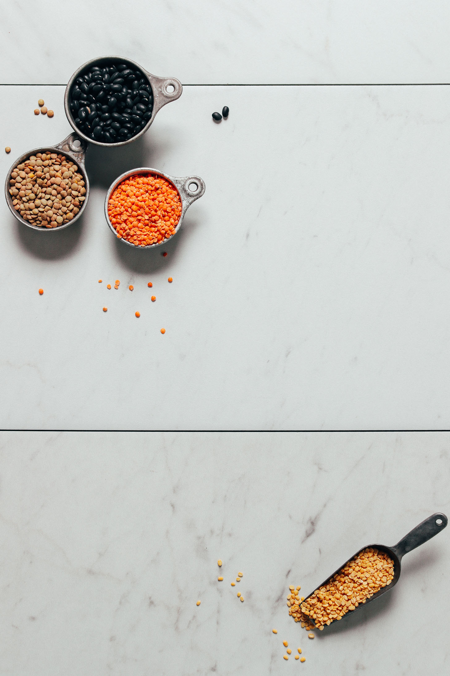 Measuring cups of various dried legumes for our guide on How to Stock Your Pantry