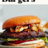 Tray with a balsamic portobello burger on a bun with caramelized onions, tomato, lettuce, and garlic aioli