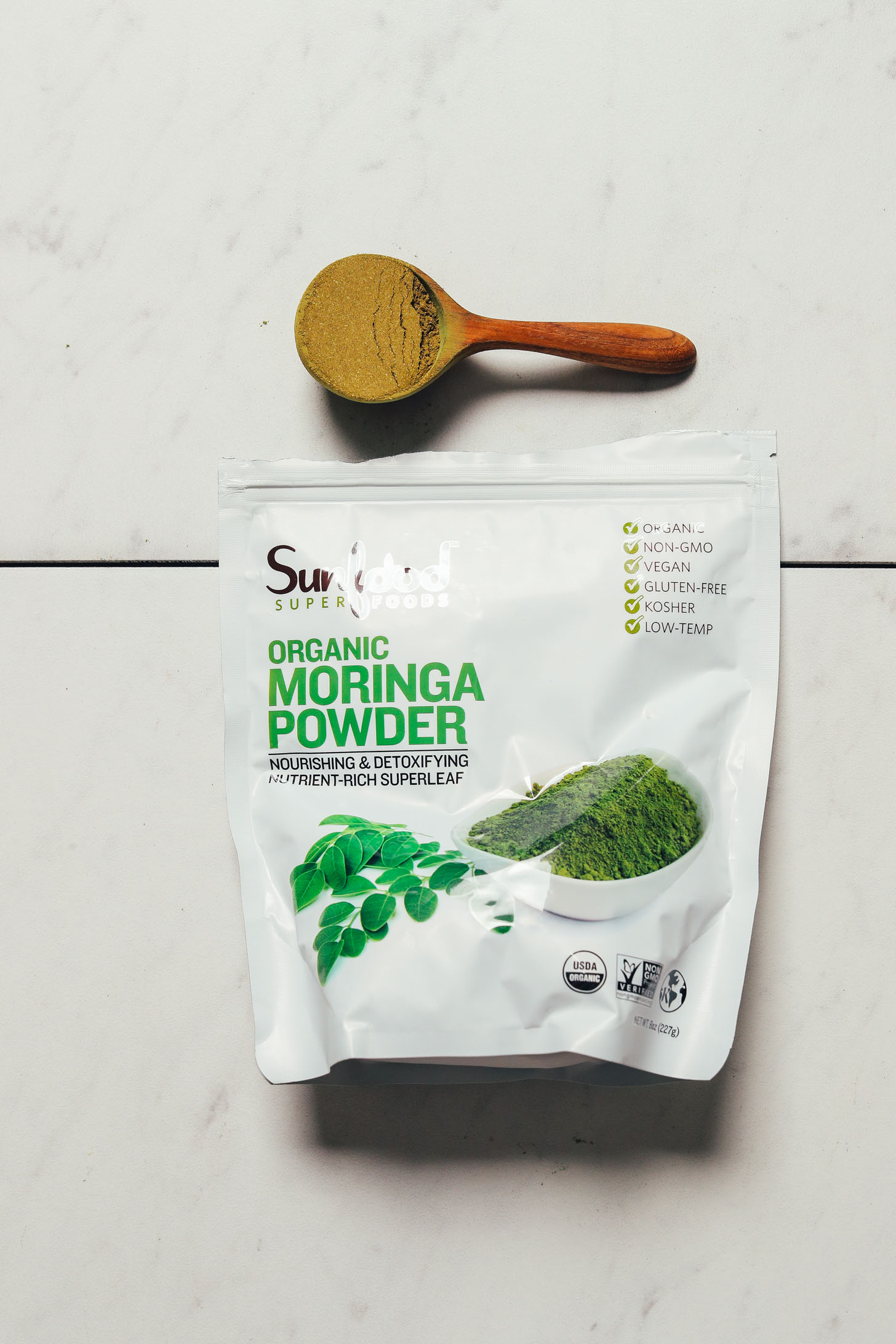 Bag and spoonful of Sunfood Moringa Powder for our review of the top moringa brands