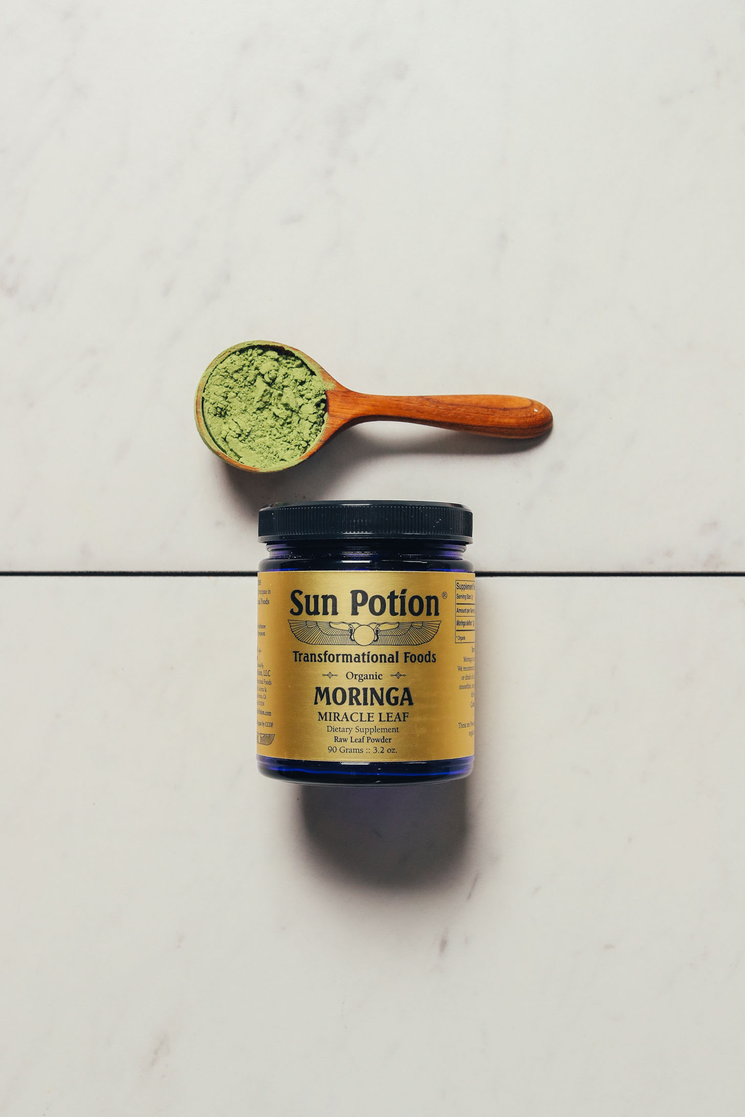 Spoonful and jar of Sun Potion Moringa Powder for our review of the best moringa powder brands