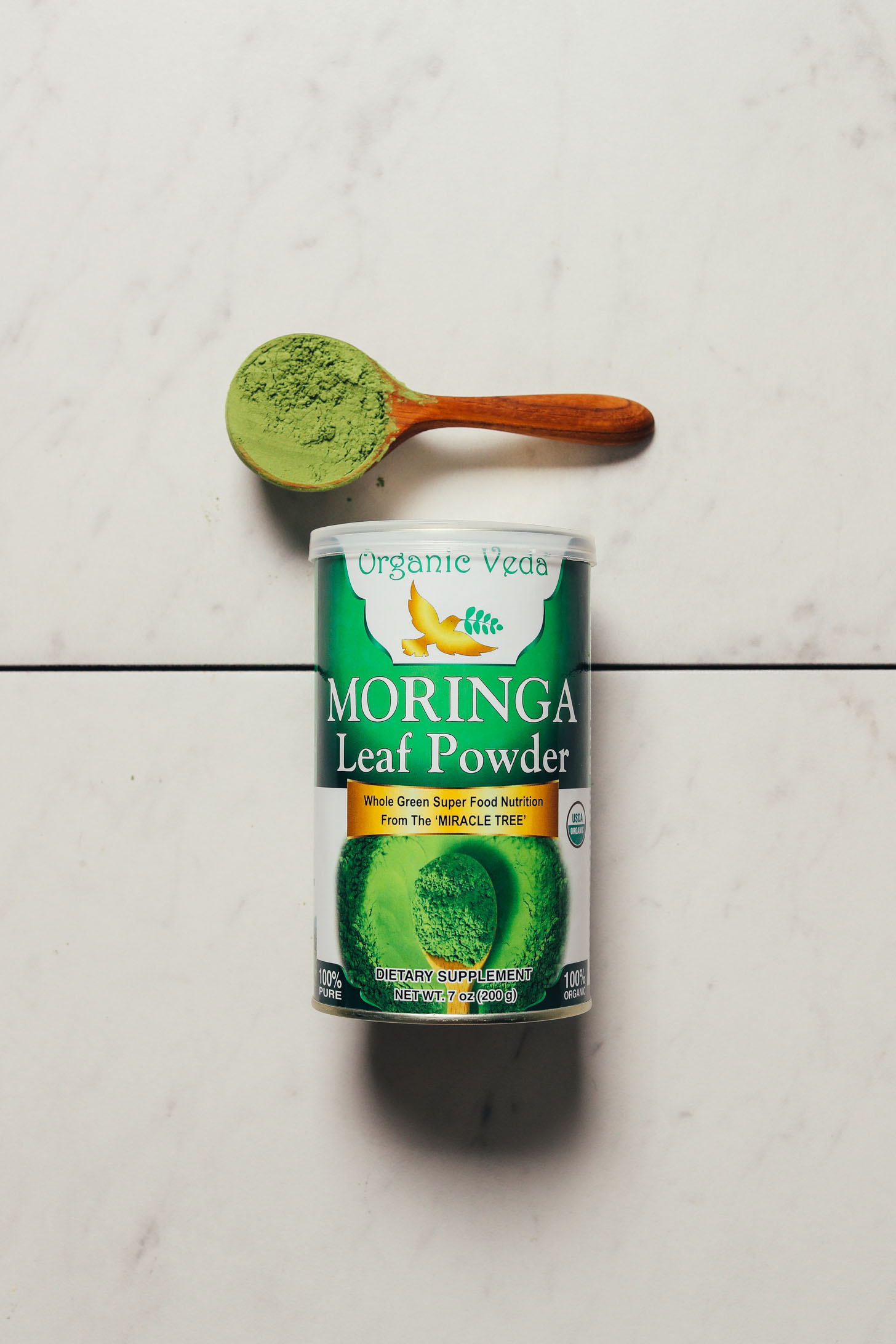 Jar and spoonful of Organic Veda moringa powder for our review of the best brands