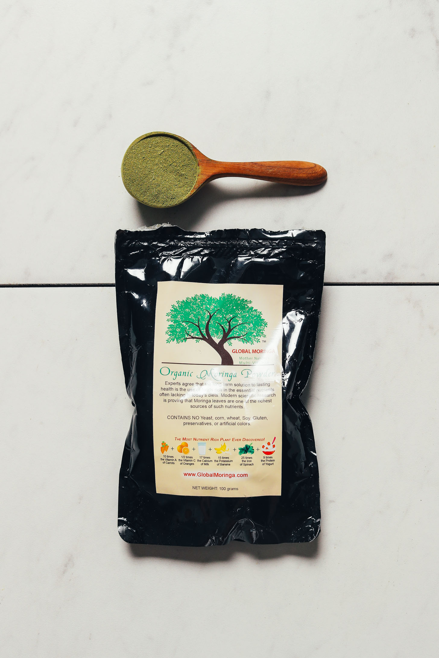Bag and spoonful of Global Traditions Moringa powder for our review of moringa powder brands