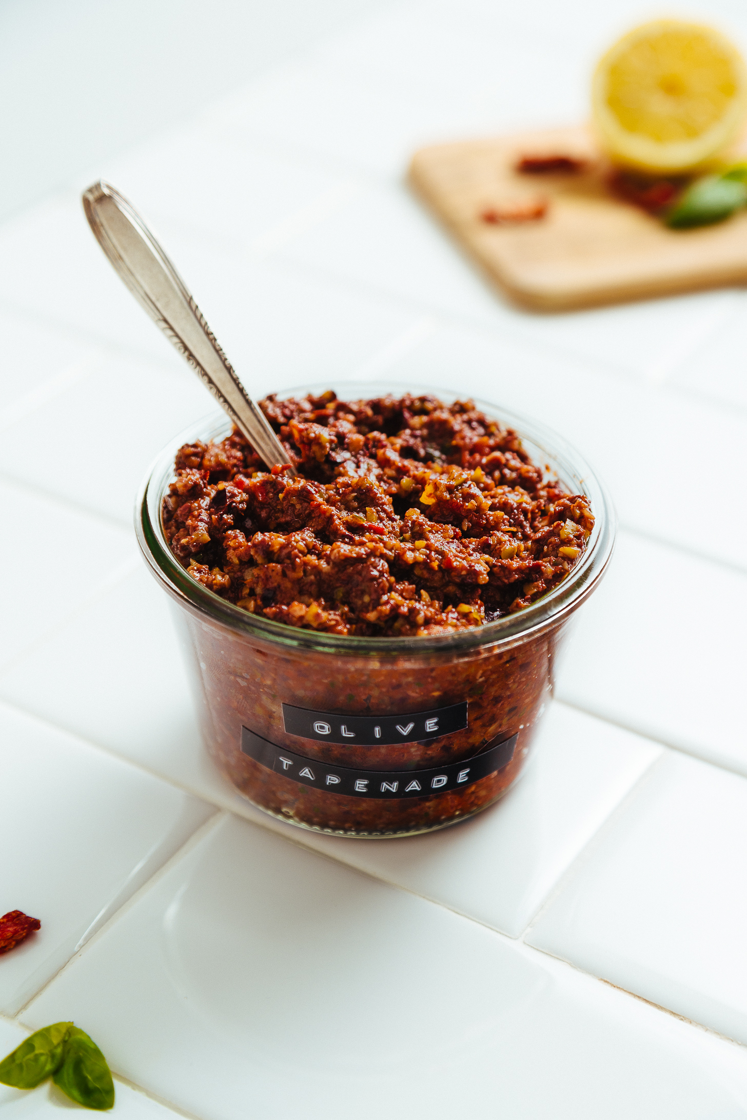 Spoon in a jar of homemade Sun-Dried Tomato and Basil Olive Tapenade