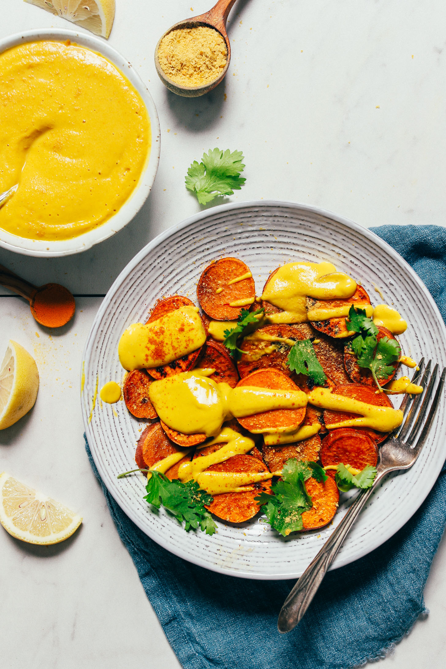 Liquid Gold Sauce drizzled over a bowl of sweet potato rounds and topped with fresh cilantro