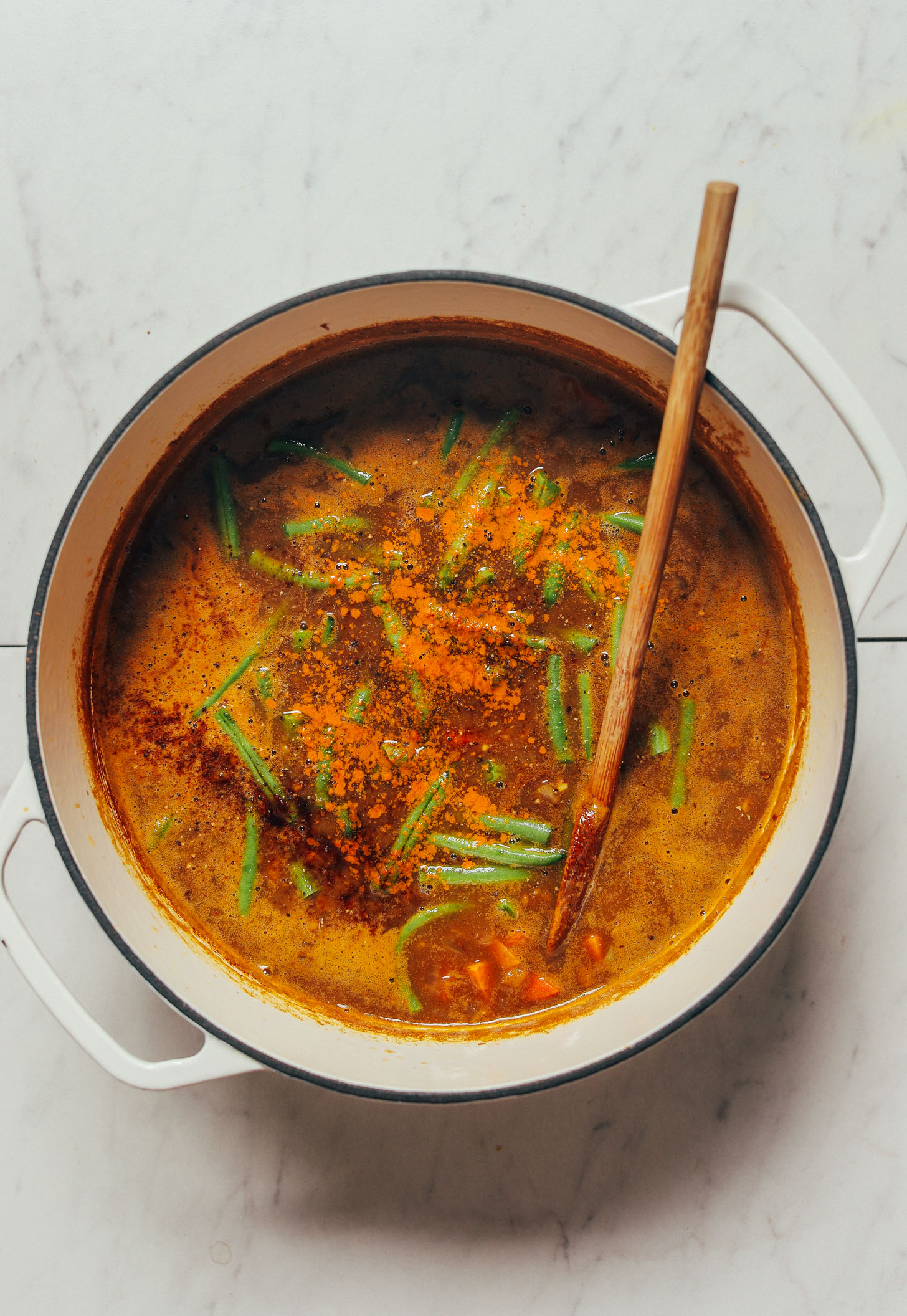 Wooden spoon resting in our 1-Pot Spiced Sweet Potato Lentil Soup recipe