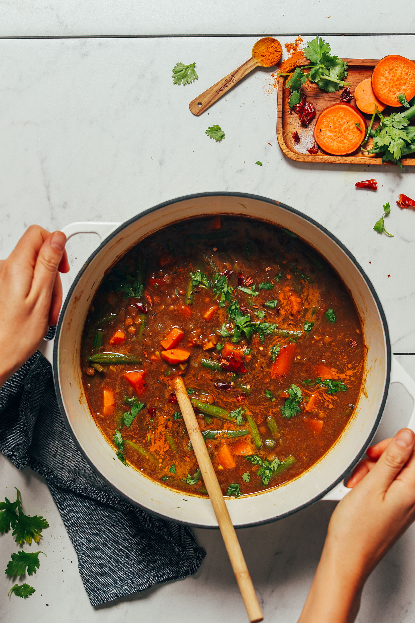 Holding a pot of our vegan Spiced Sweet Potato Lentil Soup recipe