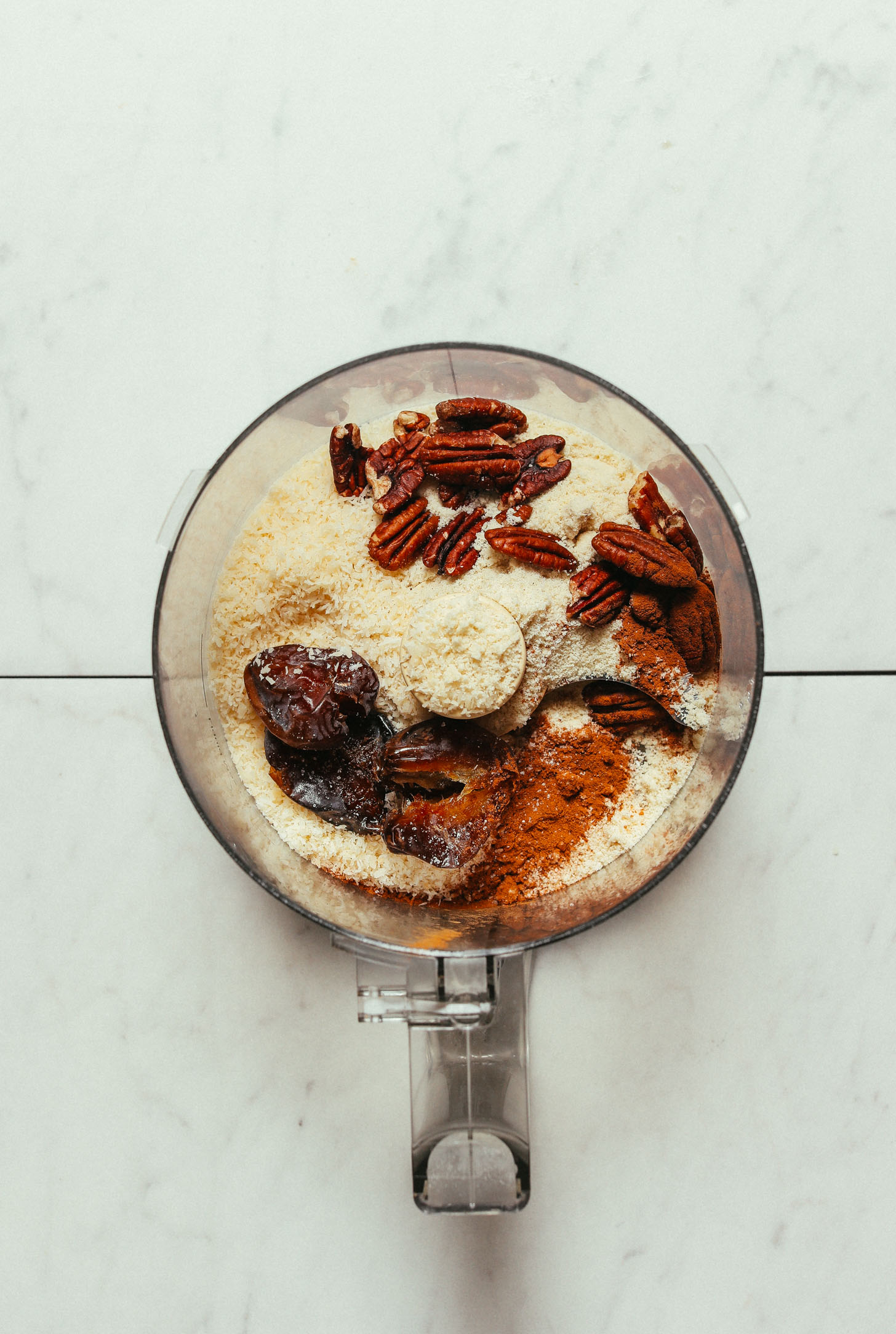 Food processor filled with ingredients to make our healthy Raw Fruit Crisp recipe