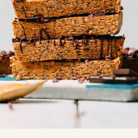 Homemade Peanut Butter Chocolate Protein Bars stacked on a tile