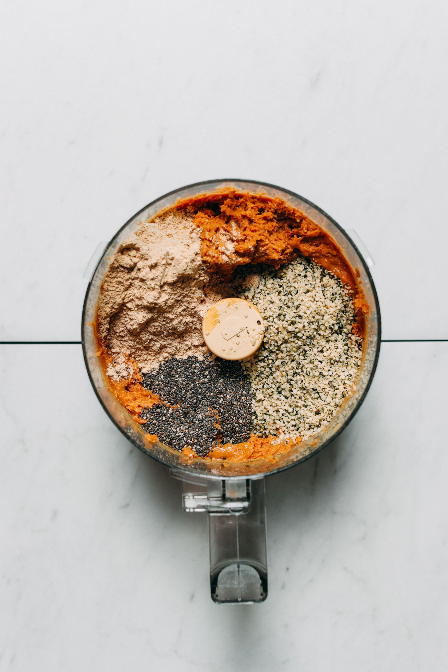 Food processor filled with ingredients for making grain-free low sugar protein bars