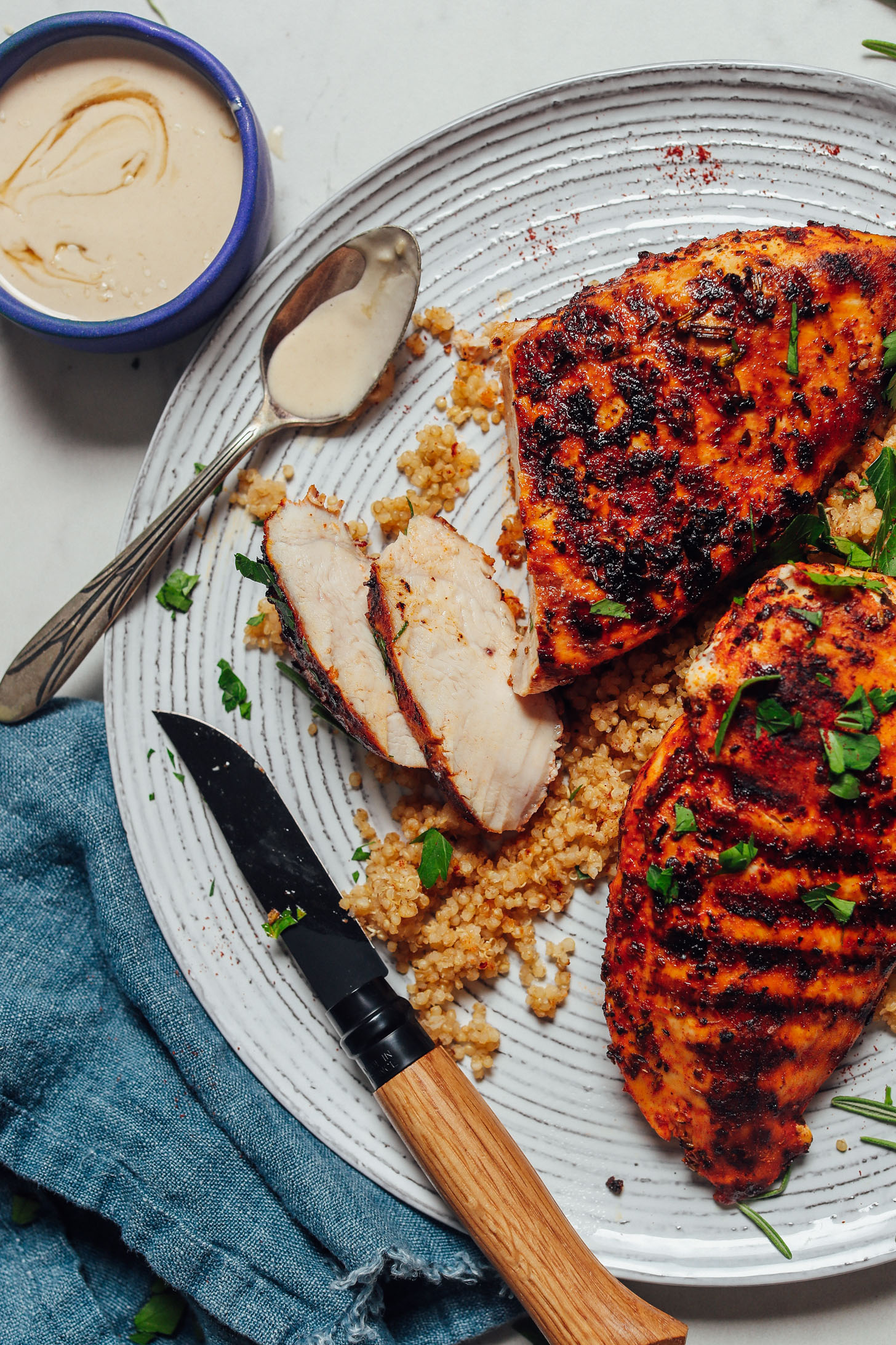 Marinated Grilled Chicken Breasts on a plate with chicken and tahini sauce for serving