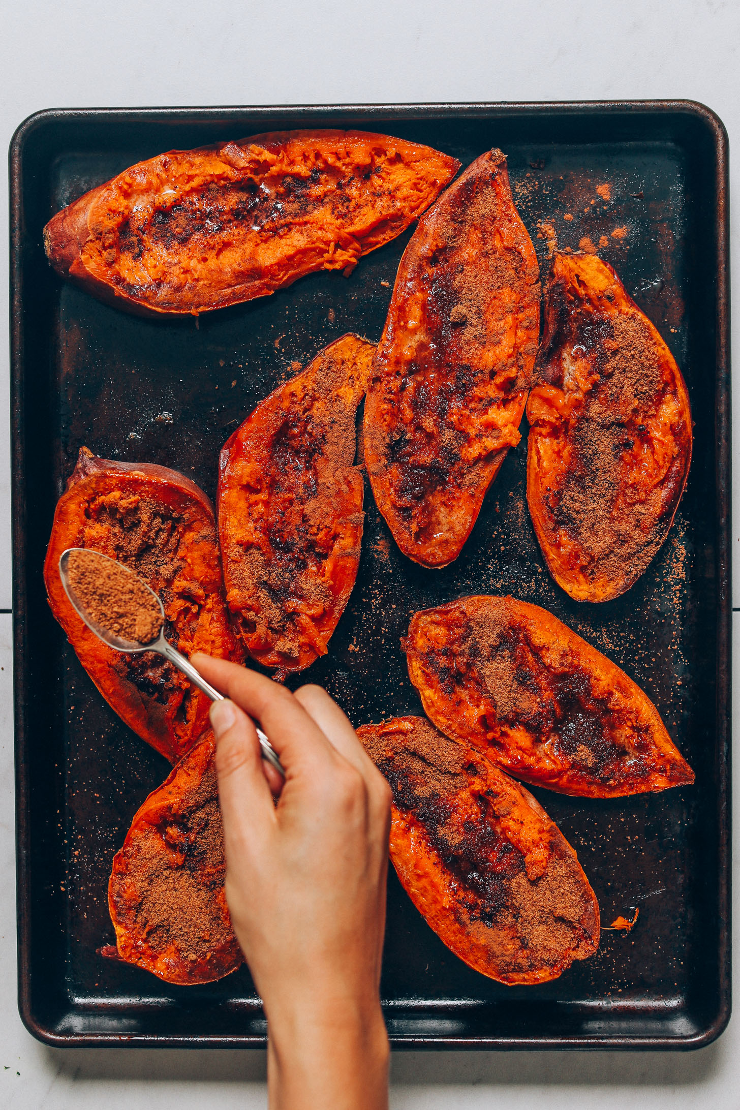 Sprinkling coconut sugar on halved, baked sweet potatoes to make Sweet Potato Casserole Boats