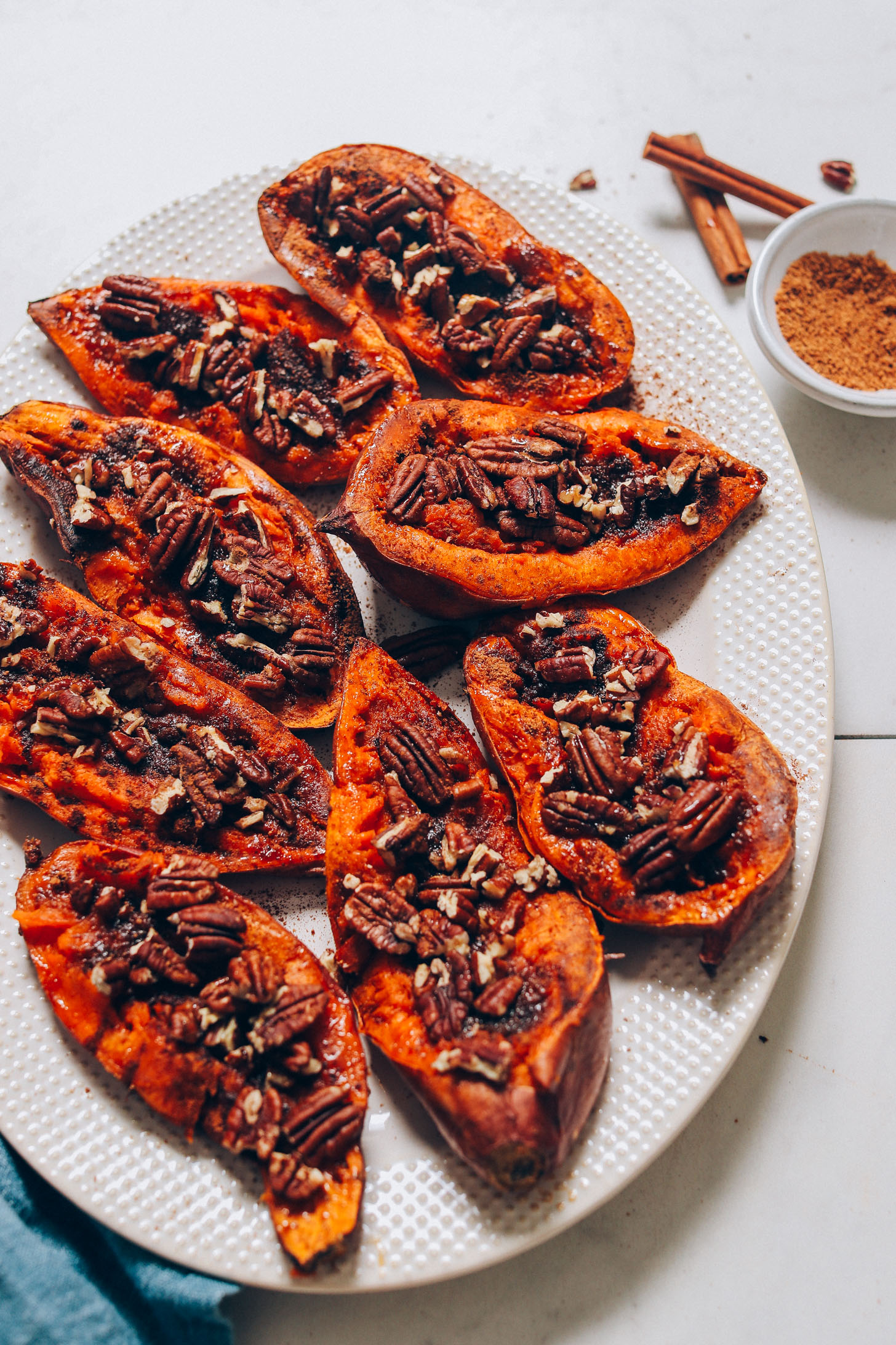 Sweet Potato Casserole Boats beside cinnamon sticks and a bowl of coconut sugar