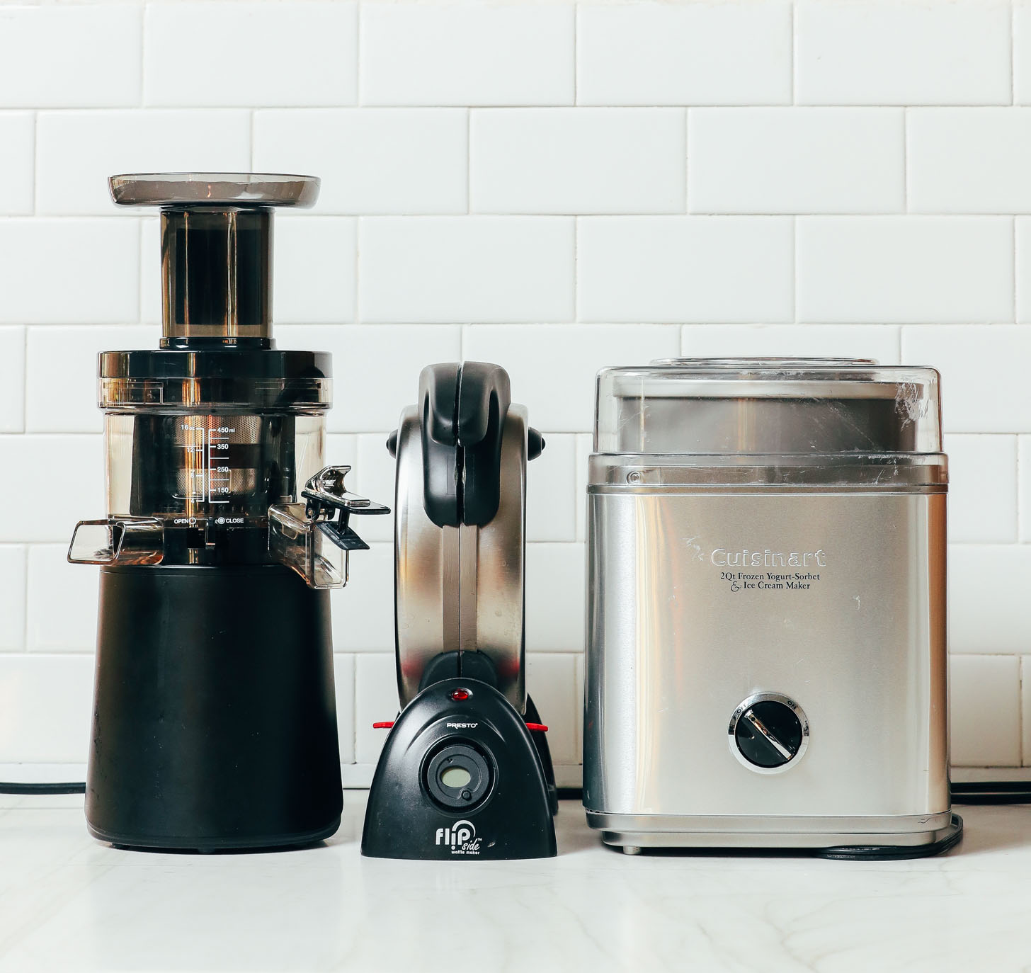A juicer, waffle maker, and ice cream maker as some of the kitchen appliances we recommend in our guide on How to Stock a Pantry