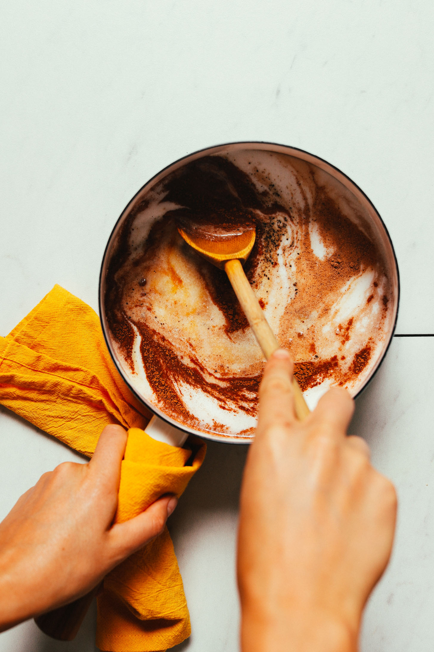 Stirring spices into a saucepan of coconut milk and water to make our DIY Pumpkin Spice Latte recipe