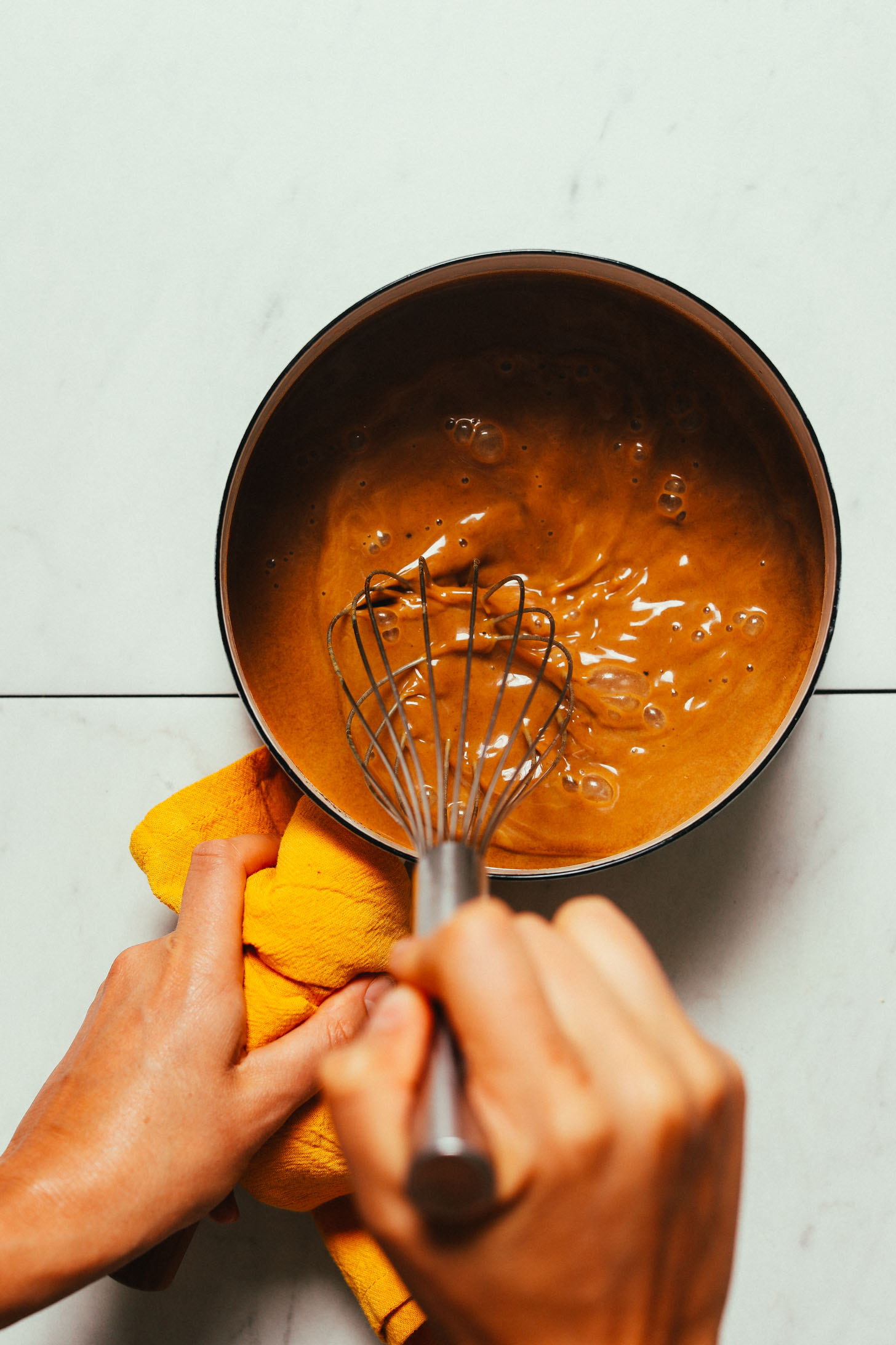 Whisking pumpkin puree in a saucepan to make our homemade Pumpkin Spice Latte recipe