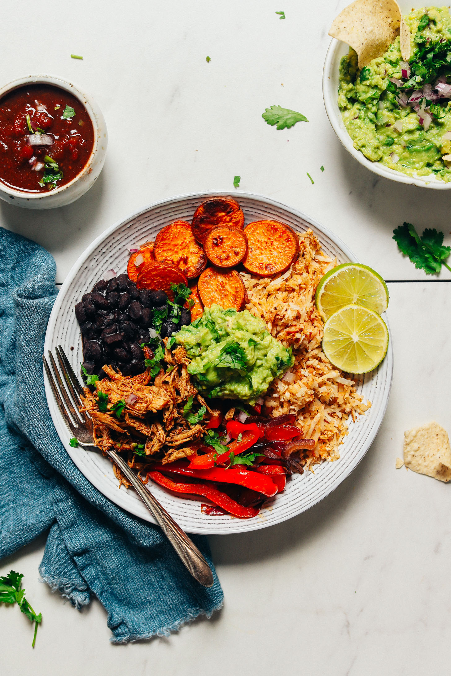 Bowls of fresh salsa and guacamole beside a homemade Grain-Free Burrito Bowl