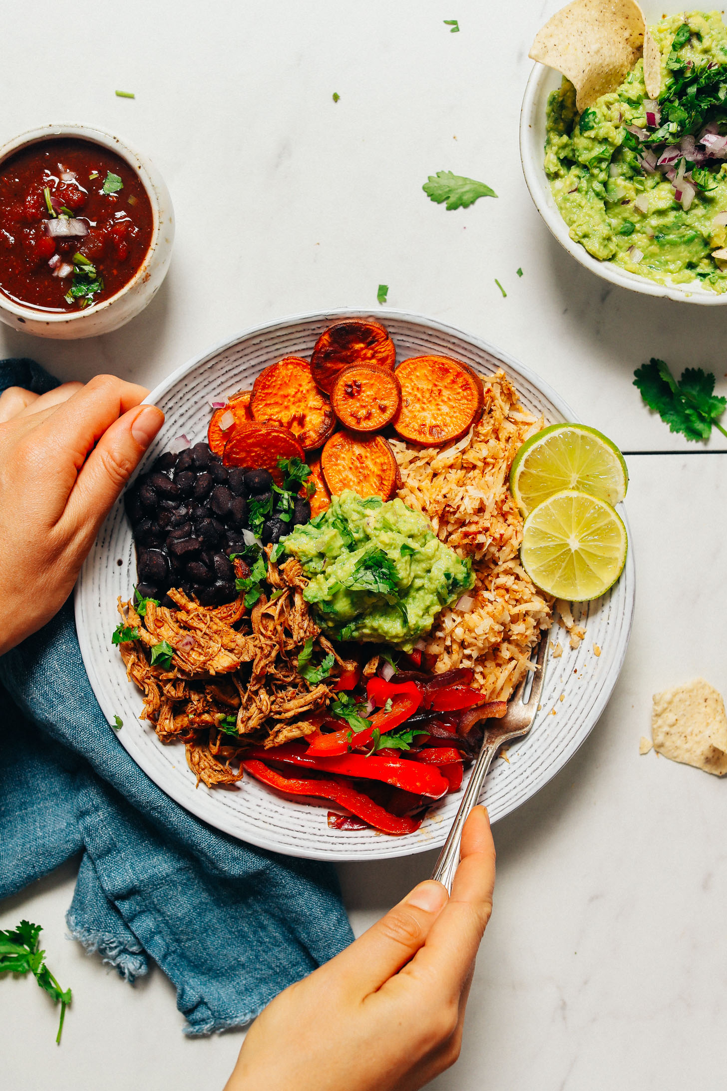 Holding a Grain-Free Burrito Bowl made with shredded chicken and cauliflower rice
