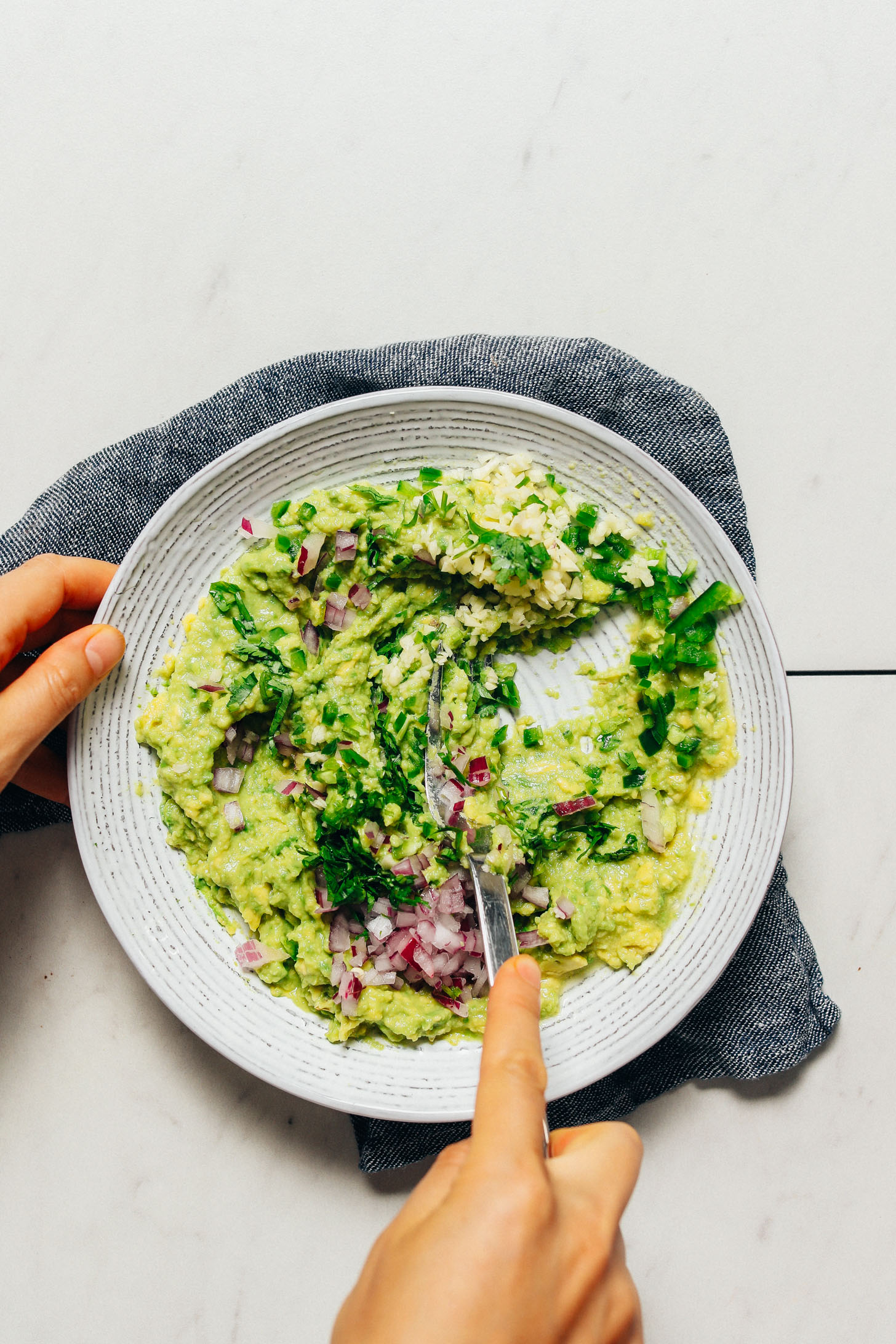 Mixing ingredients for homemade Guacamole for adding to Grain-Free Burrito Bowls
