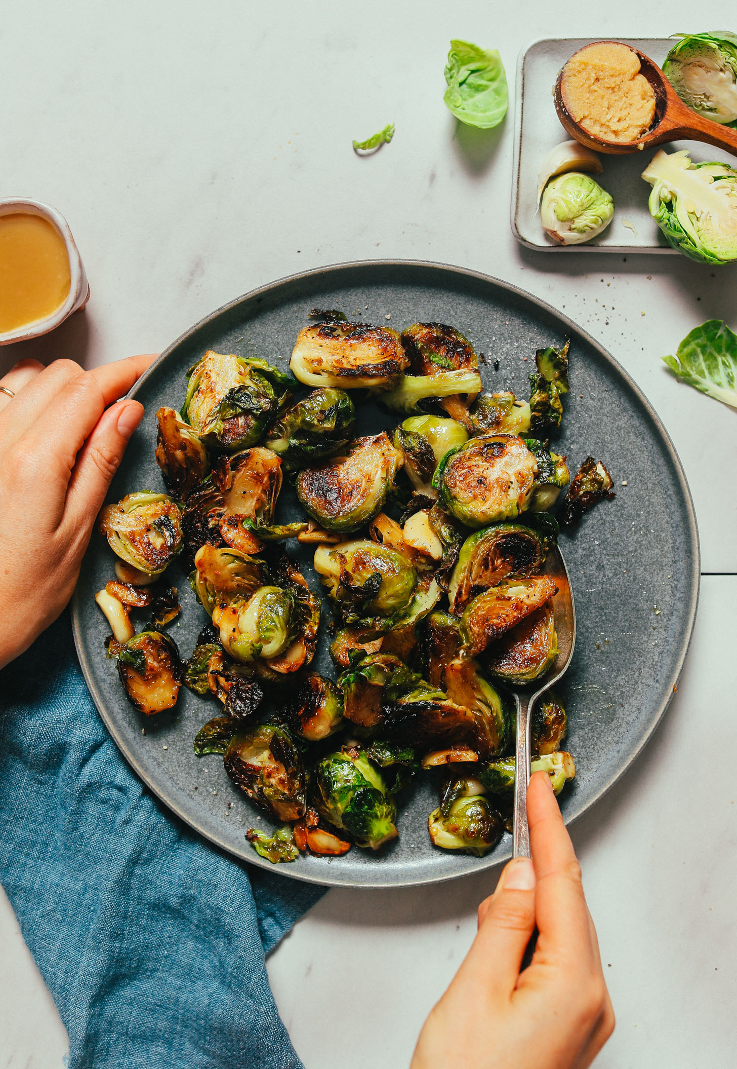 Plate of Miso-Glazed Roasted Brussels Sprouts beside ingredients used to make them