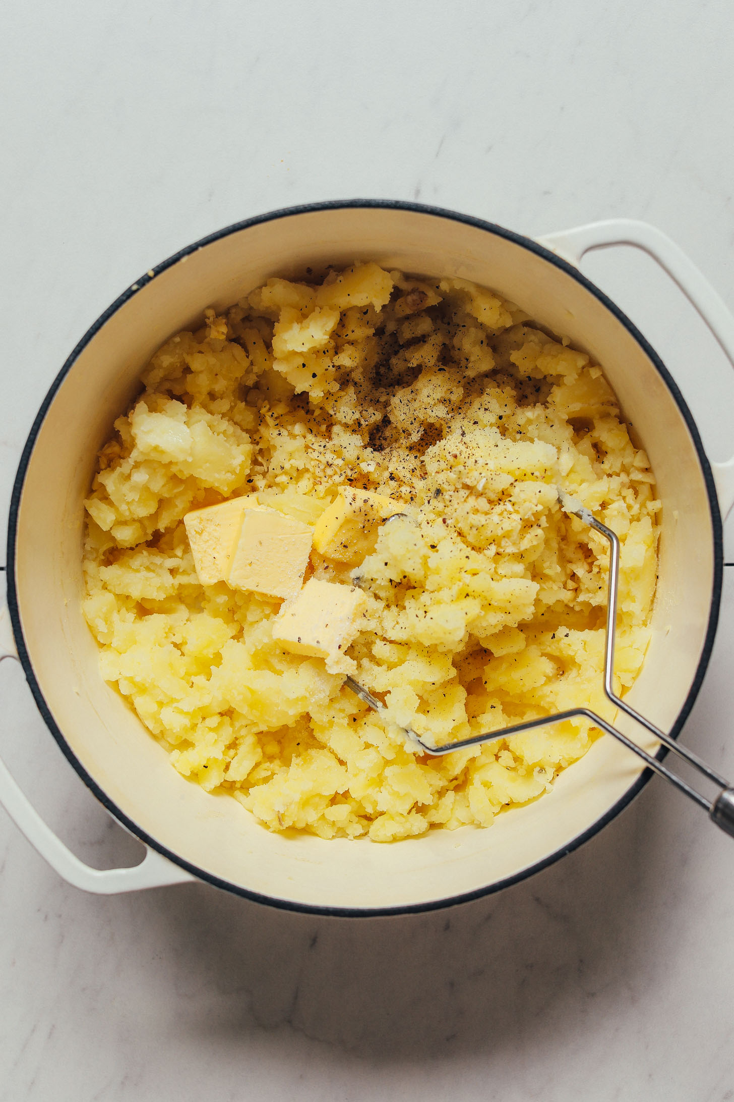 Pot of mashed potatoes with slices of vegan butter