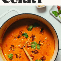 Dutch oven filled with curry and tofu with text above that says easy 1-pot Massaman curry dairy-free and gluten-free