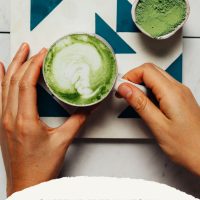 Holding a mug of our Moringa Latte recipe for a comforting and healthy morning beverage