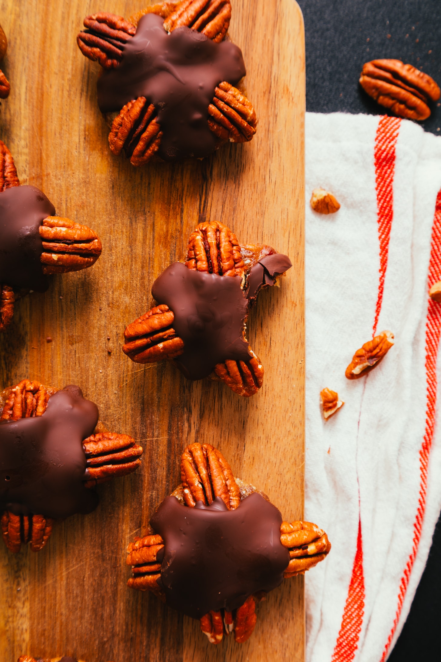 Cutting board with homemade Chocolate Turtles with one partially eaten