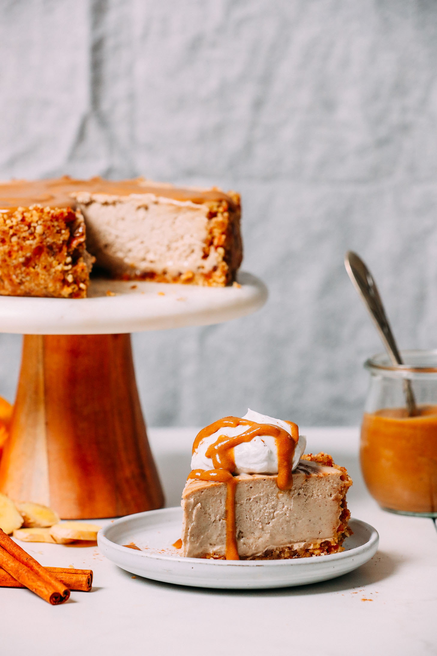 Slice of vegan cheesecake made with chai spices resting beside the rest of the cheesecake