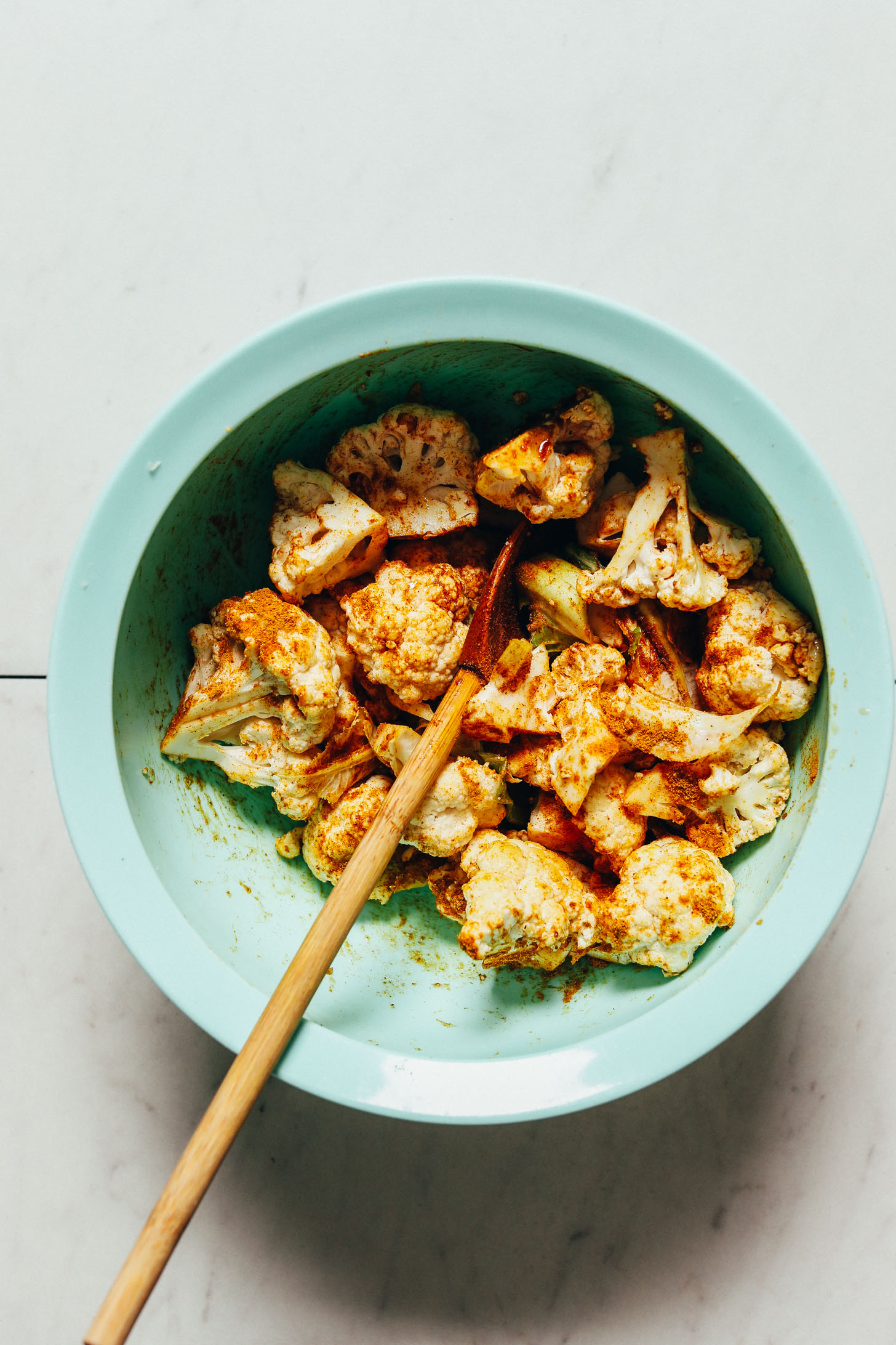 Bowl of cauliflower florets coated in curry powder