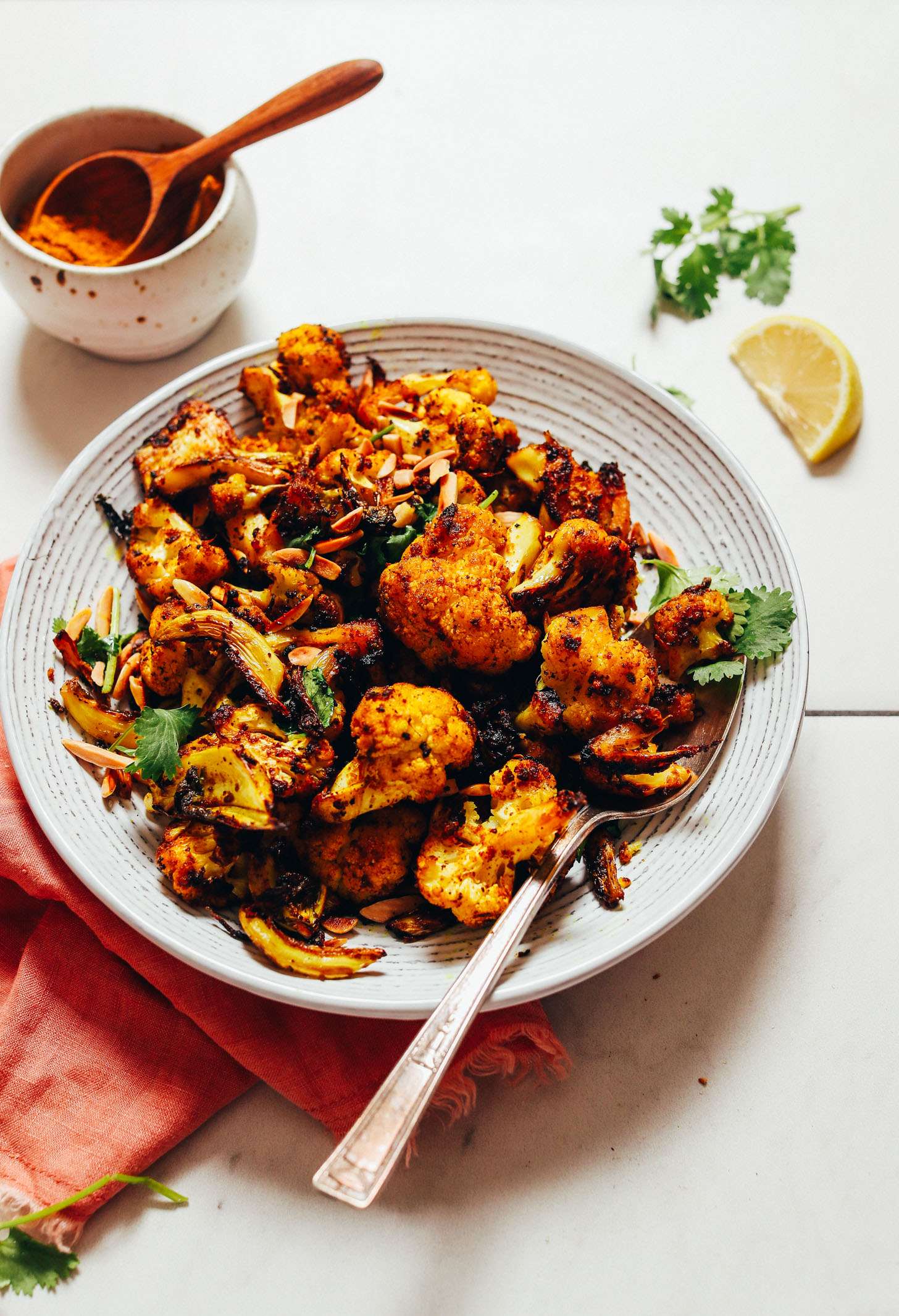 Bowl of our Quick Crispy Cauliflower recipe made with slivered almonds and cilantro