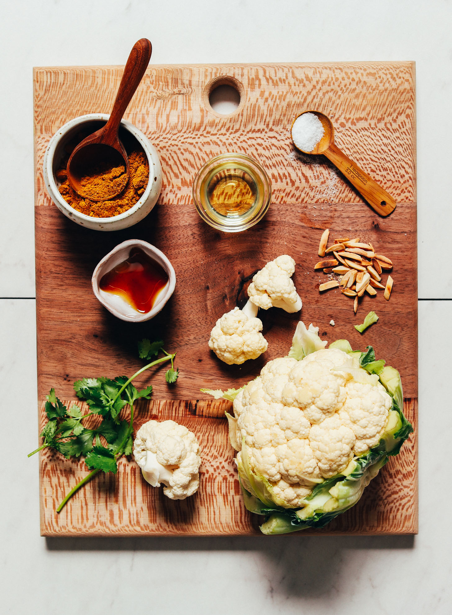 Wood cutting board with ingredients for making our Quick Crispy Cauliflower recipe