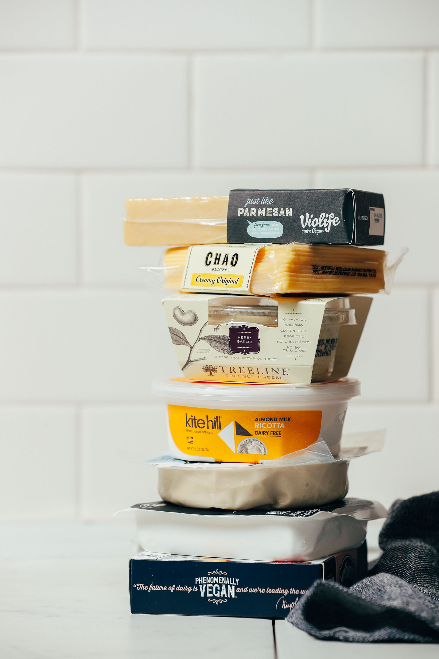 Stack of store-bought vegan cheeses for our Guide to Vegan Cheese