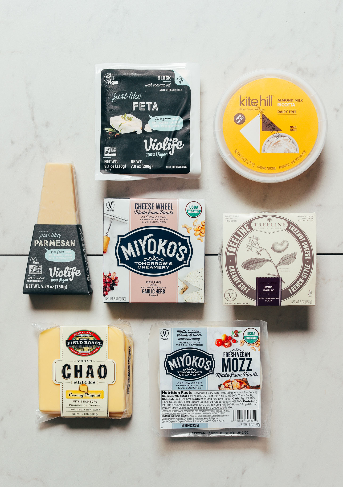 Top down shot of various brands of store-bought vegan cheeses for our unbiased review