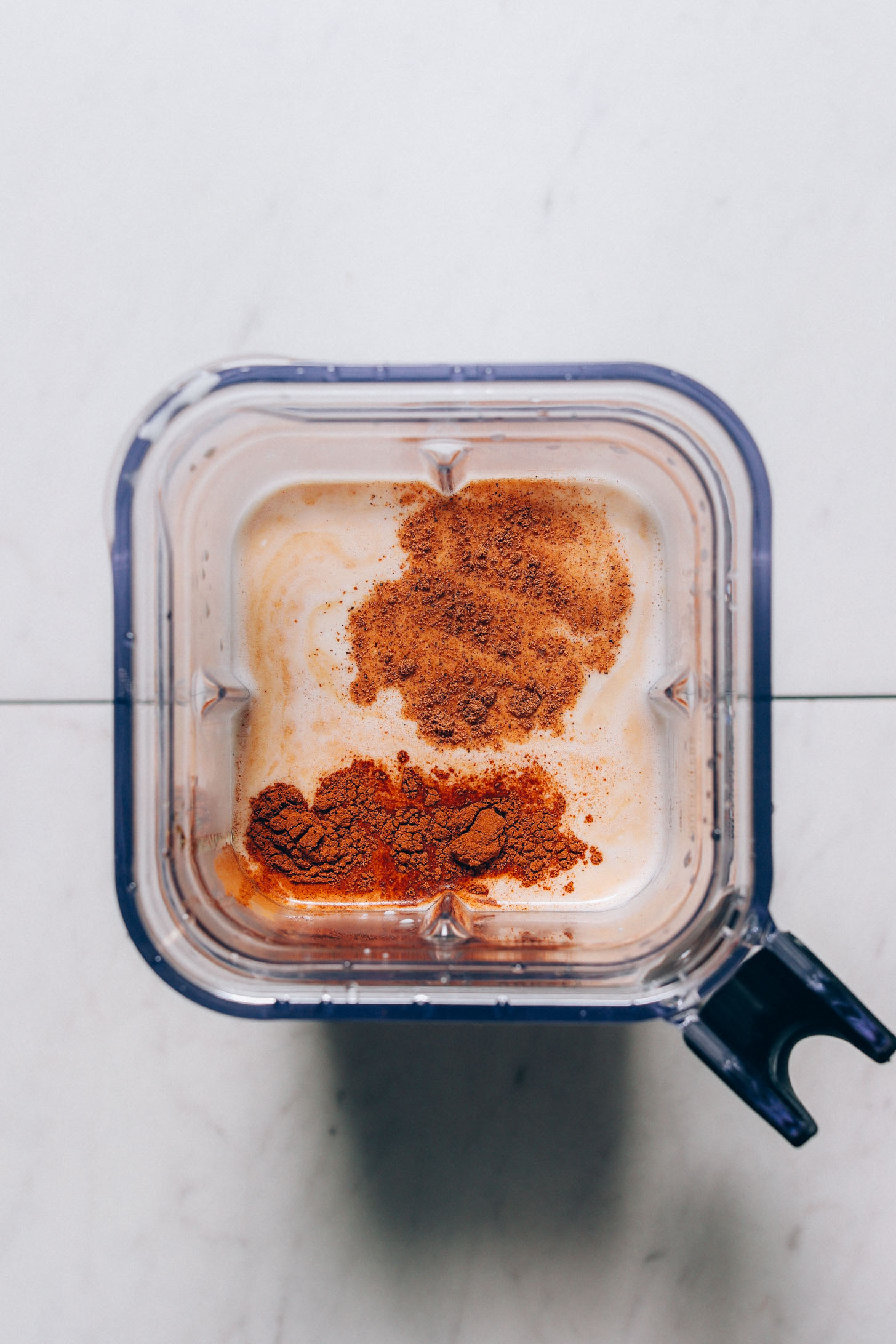 Blender filled with ingredients for making our Creamy Vegan Eggnog recipe